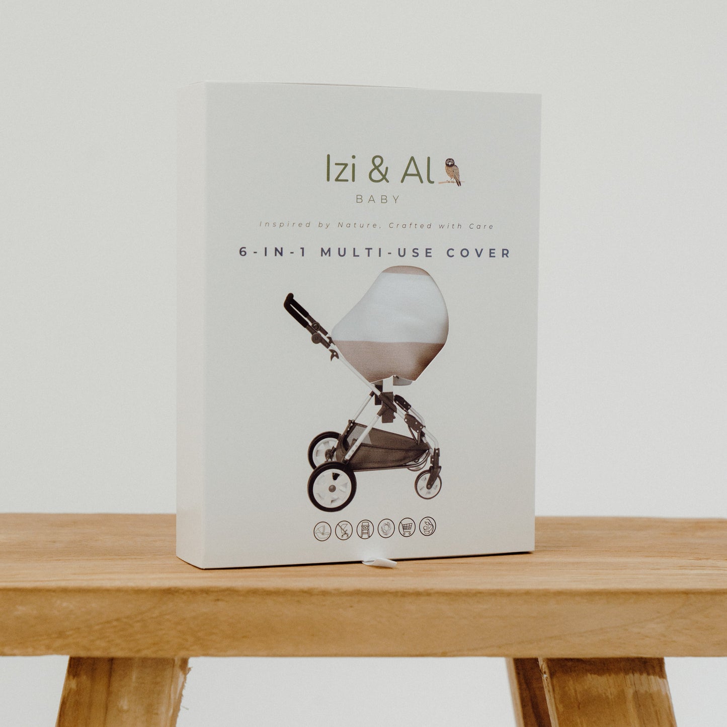Izi & Ali 6-in-1 multi-use cover packaging on a wooden table with a white background