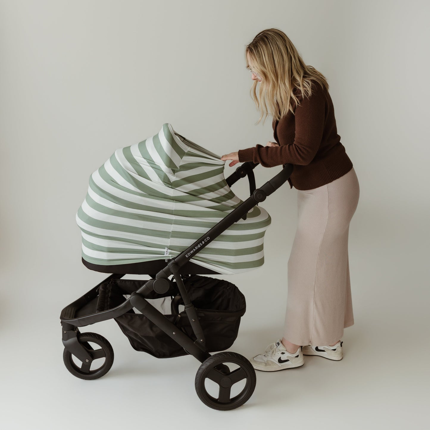 Mum looking into pram with Sage Stripe bamboo UPF 50+ baby cover by Izi & Al